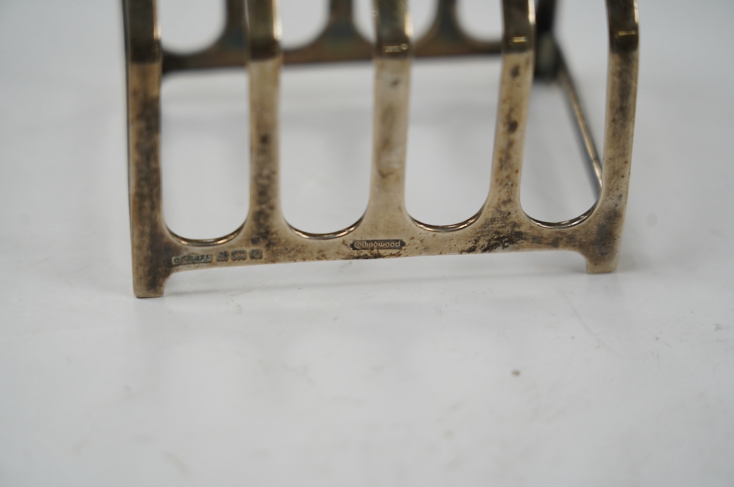 Two pairs of silver five bar toast racks, Birmingham, 1931 and Birmingham, 1932, 75mm, 10.7oz. Condition - fair